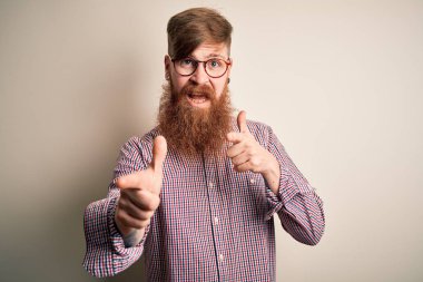 Handsome Irish redhead business man with beard wearing glasses over isolated background pointing fingers to camera with happy and funny face. Good energy and vibes.