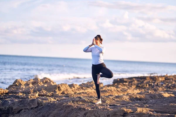年轻美丽的女运动员笑着快乐地练习瑜伽 教练脸上挂着笑容在海滩上教树摆姿势 — 图库照片