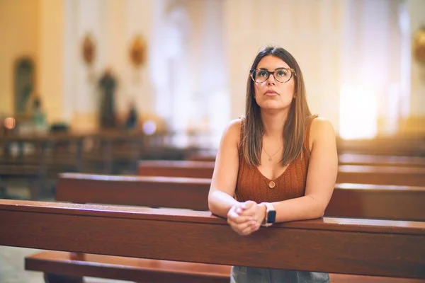 Μια Νεαρή Όμορφη Γυναίκα Προσεύχεται Γονατιστή Ένα Παγκάκι Στην Εκκλησία — Φωτογραφία Αρχείου