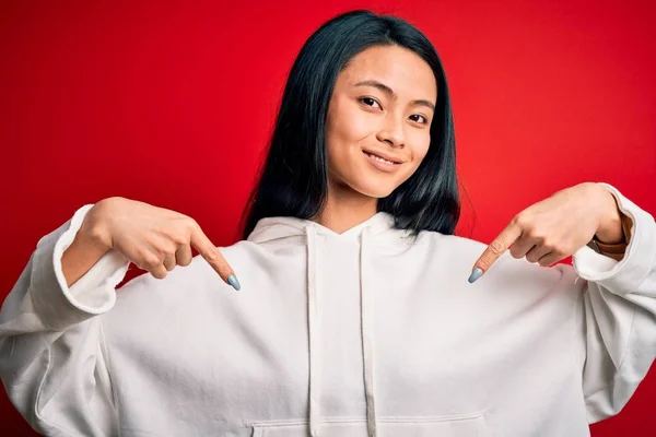 Young Beautiful Chinese Sporty Woman Wearing Sweatshirt Isolated Red Background — 스톡 사진