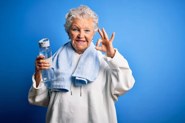 Senior Beautiful Sporty Woman Holding Bottle Water Standing Isolated Blue — Stok fotoğraf