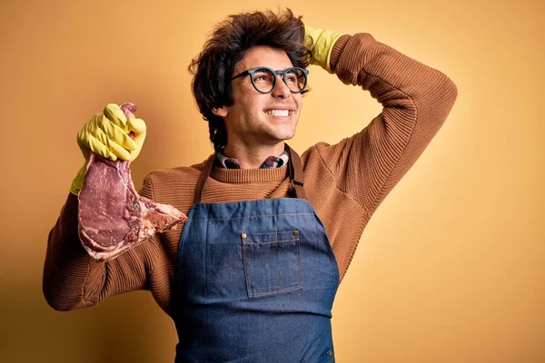 Young Handsome Butcher Man Holding Meet Steak Standing Isolated Yellow — Stok fotoğraf