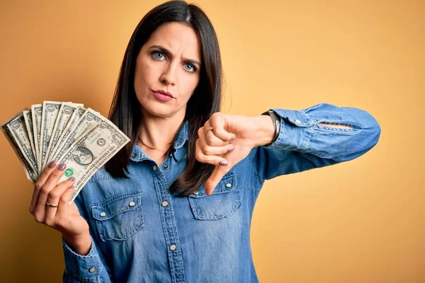 Young Brunette Woman Blue Eyes Holding Dollar Banknotes Yellow Isolated — Stockfoto