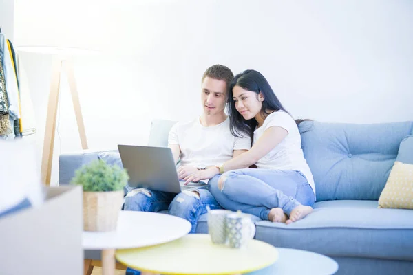年轻美丽的夫妇坐在坐在坐在一张小瓦的电脑在新家周围的纸板箱 — 图库照片