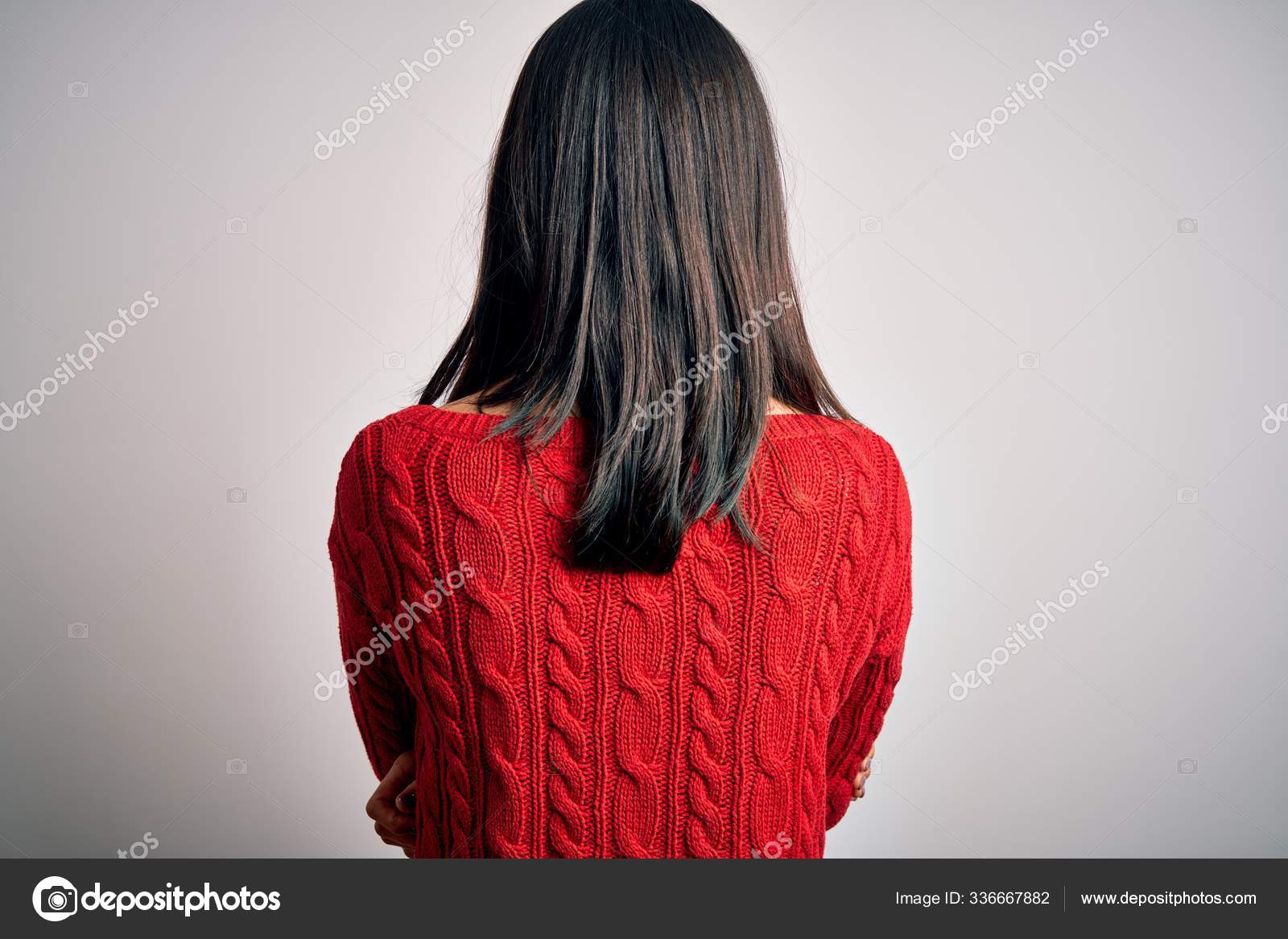 Fotos de Triste morena feminino em pé no perfil com os braços cruzados