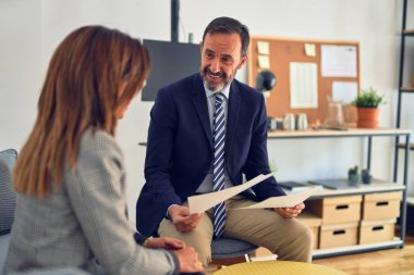Mutlu ve kendinden emin gülümseyen iki orta yaşlı iş adamı. Ofiste evrakları tutarken gülümseme ile birlikte çalışmak.