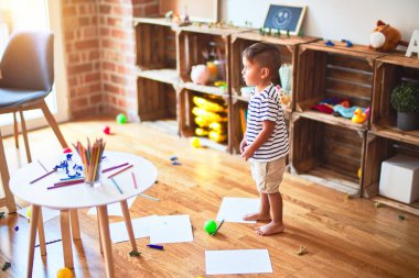 Anaokulunda bir sürü oyuncakla bekleyen güzel bir çocuk.