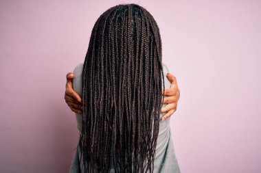Young african american business woman standing over pink isolated background Hugging oneself happy and positive from backwards. Self love and self care