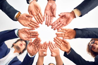 Bir grup iş adamı mutlu ve kendinden emin gülümsüyor. Yüzünde bir gülümsemeyle bir çemberin üzerinde durarak ofiste el ele tutuşarak semboller çizerek..