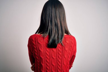Young brunette woman with blue eyes wearing casual sweater over isolated white background standing backwards looking away with crossed arms