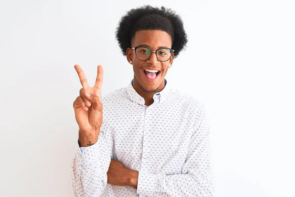 エレガントなシャツと眼鏡を身に着けている若いアフリカ系アメリカ人の男性は 勝利のサインを行うカメラで幸せな顔をウィンクと笑顔隔離された白い背景に 第二番 — ストック写真