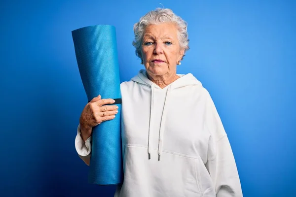 Senior Beautiful Sporty Woman Holding Mat Yoga Standing Isolated Blue — Stok fotoğraf