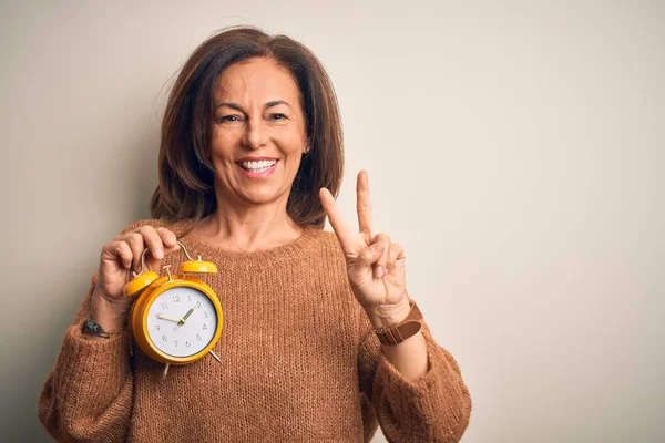 Middle Age Brunette Woman Holding Clasic Alarm Clock Isolated Background — Stok fotoğraf