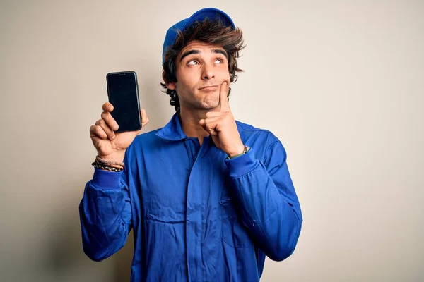 Jovem Mecânico Homem Vestindo Uniforme Segurando Smartphone Sobre Fundo Branco — Fotografia de Stock