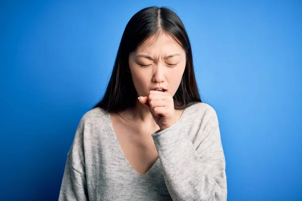 Młoda Piękna Azjatycka Kobieta Luźnym Swetrze Stojąca Nad Niebieskim Odizolowanym — Zdjęcie stockowe