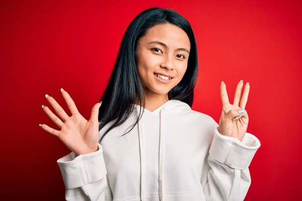 Jonge Mooie Chinese Sportieve Vrouw Dragen Sweatshirt Geïsoleerde Rode Achtergrond — Stockfoto