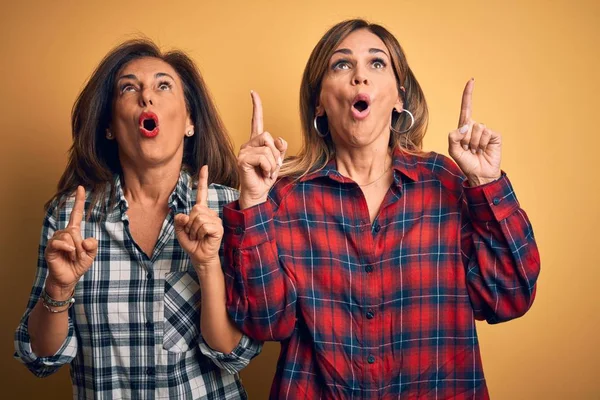 Middelbare Leeftijd Mooi Paar Zussen Dragen Casual Shirt Geïsoleerde Gele — Stockfoto