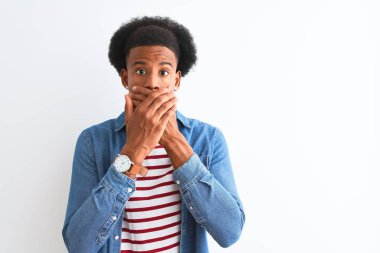İzole edilmiş beyaz arka plan üzerine çizgili tişört ve kot ceket giyen Afro-Amerikan bir adam yanlışlıkla ağızlarını kapatarak şok etti. Gizli konsept.