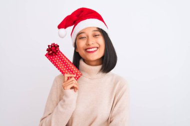 Genç Çinli temizlikçi kadın eldivenleriyle izole edilmiş beyaz arka planı paspaslıyor. Mutlu bir yüzü var ve gülümsüyor. Dişlerini gösteren bir gülümsemeyle.