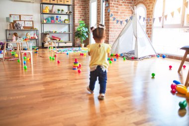 Anaokulunda çizgili pipetlerle oynayan güzel bir çocuk.