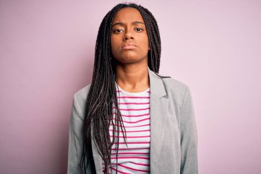 Genç Afrikalı Amerikalı iş kadını pembe soyutlanmış arka planda duruyor. Uykulu ve yorgun görünüyor. Yorgun ve akşamdan kalma, tembel bakışlar..