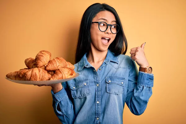 Jovem Mulher Chinesa Bonita Segurando Placa Com Croissants Sobre Fundo — Fotografia de Stock