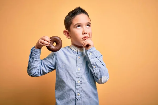 Kleiner Junge Kind Isst Ungesunde Schokolade Donut Über Isolierten Gelben — Stockfoto