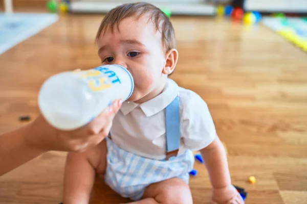 Förtjusande Barn Som Sitter Golvet Och Dricker Mjölk Med Hjälp — Stockfoto