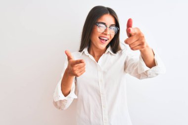 Young beautiful businesswoman wearing glasses standing over isolated white background pointing fingers to camera with happy and funny face. Good energy and vibes.