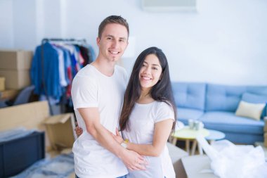 Karton kutular etrafında yeni evde sarılma genç güzel çift