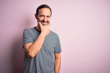 Sıradan çizgili tişört giyen orta yaşlı beyaz bir adam izole edilmiş pembe arka planda dikiliyor kameraya bakıyor kollarını kavuşturmuş ve çenesini kaldırmış şekilde gülümsüyor. Olumlu düşünüyorum..