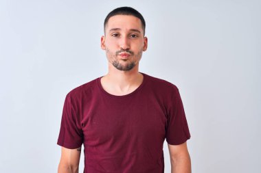 Soyutlanmış arka planda duran genç yakışıklı adam komik yüzlü yanakları tüttürüyor. Havayla şişmiş ağız, çılgın bir ifade..