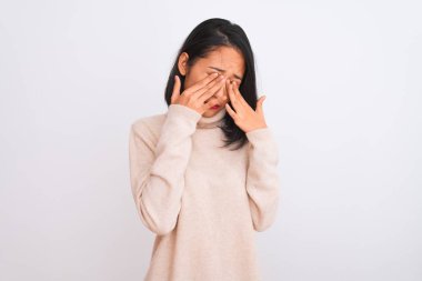 Young chinese woman wearing turtleneck sweater standing over isolated white background rubbing eyes for fatigue and headache, sleepy and tired expression. Vision problem