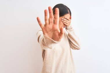Beautiful redhead woman wearing winter turtleneck sweater over isolated background covering eyes with hands and doing stop gesture with sad and fear expression. Embarrassed and negative concept.