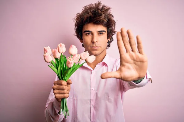 Joven Hombre Guapo Sosteniendo Flores Pie Sobre Fondo Rosa Aislado — Foto de Stock