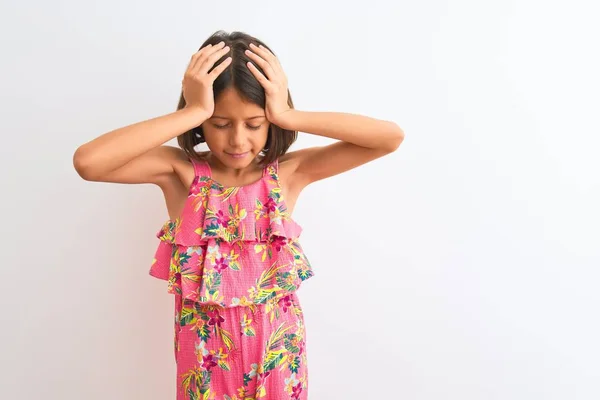 由于疼痛和偏头痛 年轻美丽的小女孩穿着粉红色的花衣服站在孤独的白色背景之上 极度头痛和紧张 手放在头上 — 图库照片