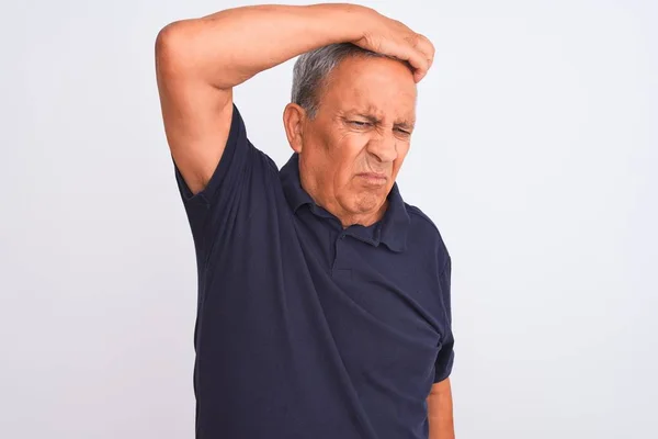 Senior grey-haired man wearing black casual polo standing over isolated white background confuse and wonder about question. Uncertain with doubt, thinking with hand on head. Pensive concept.