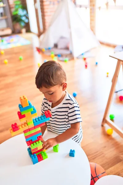 美しい幼児男の子遊びます建設ブロックで幼稚園 — ストック写真