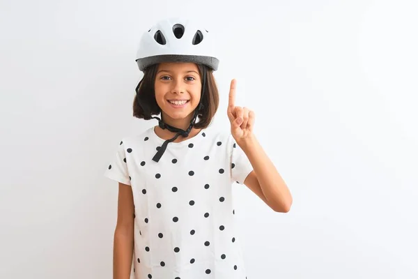 漂亮的小女孩戴着安全自行车头盔 站在孤独的白色背景上 带着第一指尖 面带微笑 自信而快乐 — 图库照片