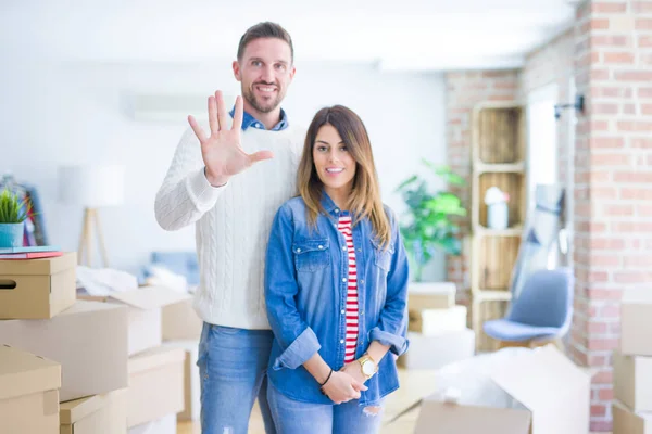 Jovem Casal Bonito Casa Nova Torno Caixas Papelão Mostrando Apontando — Fotografia de Stock