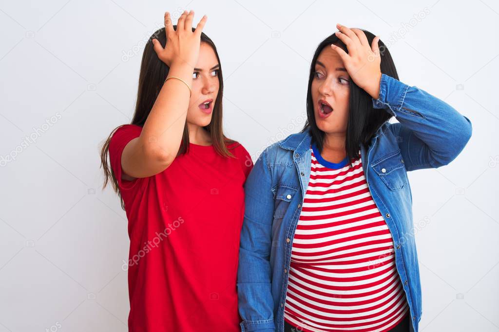 Young beautiful women wearing casual clothes standing over isolated white background surprised with hand on head for mistake, remember error. Forgot, bad memory concept.
