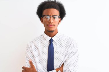Genç Afro-Amerikalı iş adamı, izole edilmiş beyaz arka plan kuşkucu ve gergin, kollarını çapraz yapıp onaylamayan bir ifade takınıp gözlük takıyor. Negatif kişi.