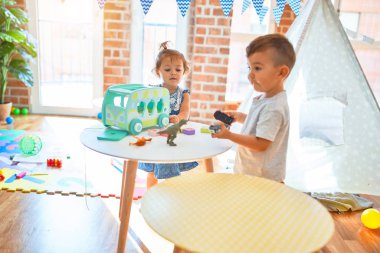 Sevimli bebekler mutlu gülümsüyor. Anaokulunda bir sürü oyuncakla oynamak.