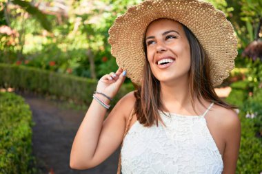 Güneşli bir yaz gününde yeşil parkta mutlu ve neşeli gülümseyen güzel bir kadın.