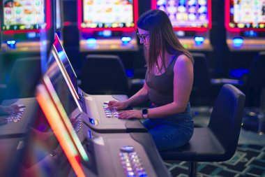 Mutlu ve kendinden emin gülümseyen genç ve güzel bir kadın. Yüzünde gülümsemeyle kumarhanede kumar oynuyordu.