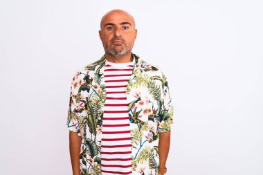 Tatilde olan orta yaşlı yakışıklı bir adam izole edilmiş beyaz bir arka plan ve yüzünde ciddi bir ifadeyle yaz gömleği giyiyor. Basit ve doğal bir şekilde kameraya bakıyorsun..