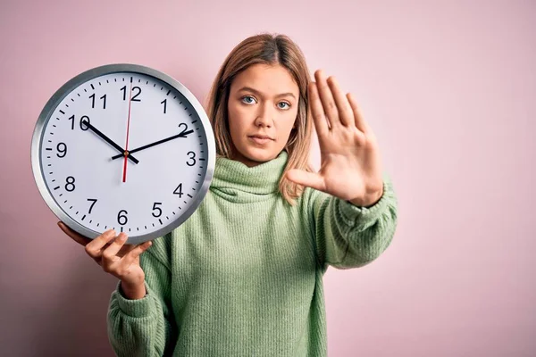 Joven Hermosa Mujer Sosteniendo Reloj Pie Sobre Fondo Rosa Aislado —  Fotos de Stock