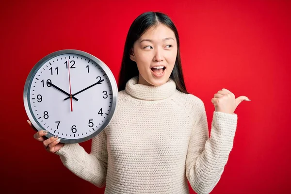 Joven Asiática Mujer Sosteniendo Cuenta Atrás Grande Reloj Sobre Rojo — Foto de Stock