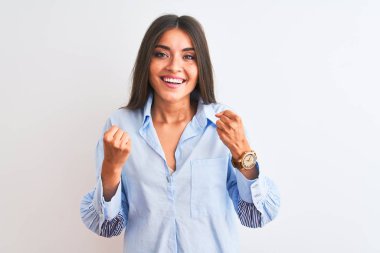 Young beautiful woman wearing blue elegant shirt standing over isolated white background celebrating surprised and amazed for success with arms raised and open eyes. Winner concept.