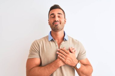 Young handsome man wearing elegant t-shirt over isolated background smiling with hands on chest with closed eyes and grateful gesture on face. Health concept.
